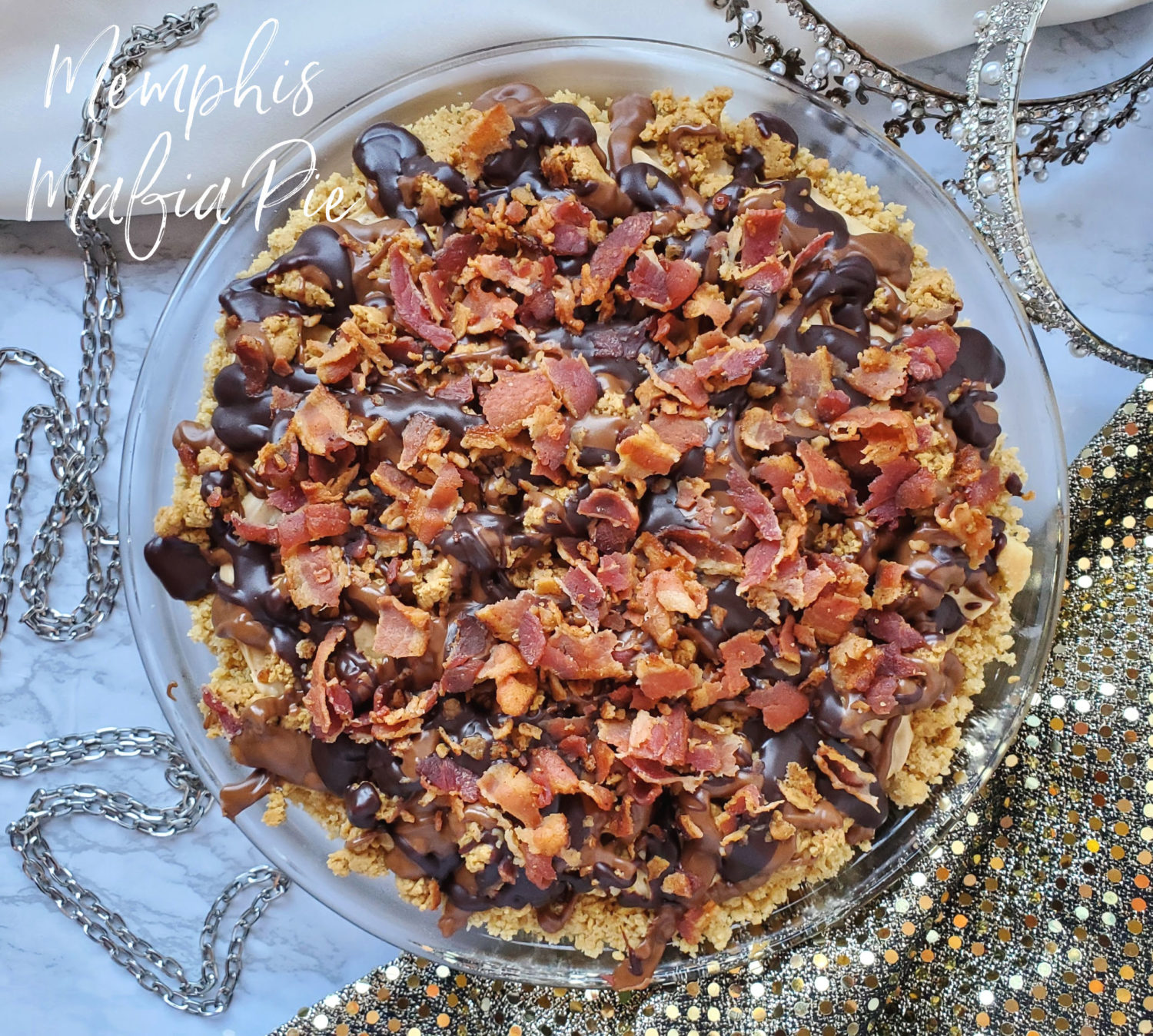 Memphis Mafia Pie: Vanilla wafer crust, peanut butter filling, bananas, homemade "Reeses" crumbles, drizzled with peanut butter fudge, chocolate ganache & bacon! 
