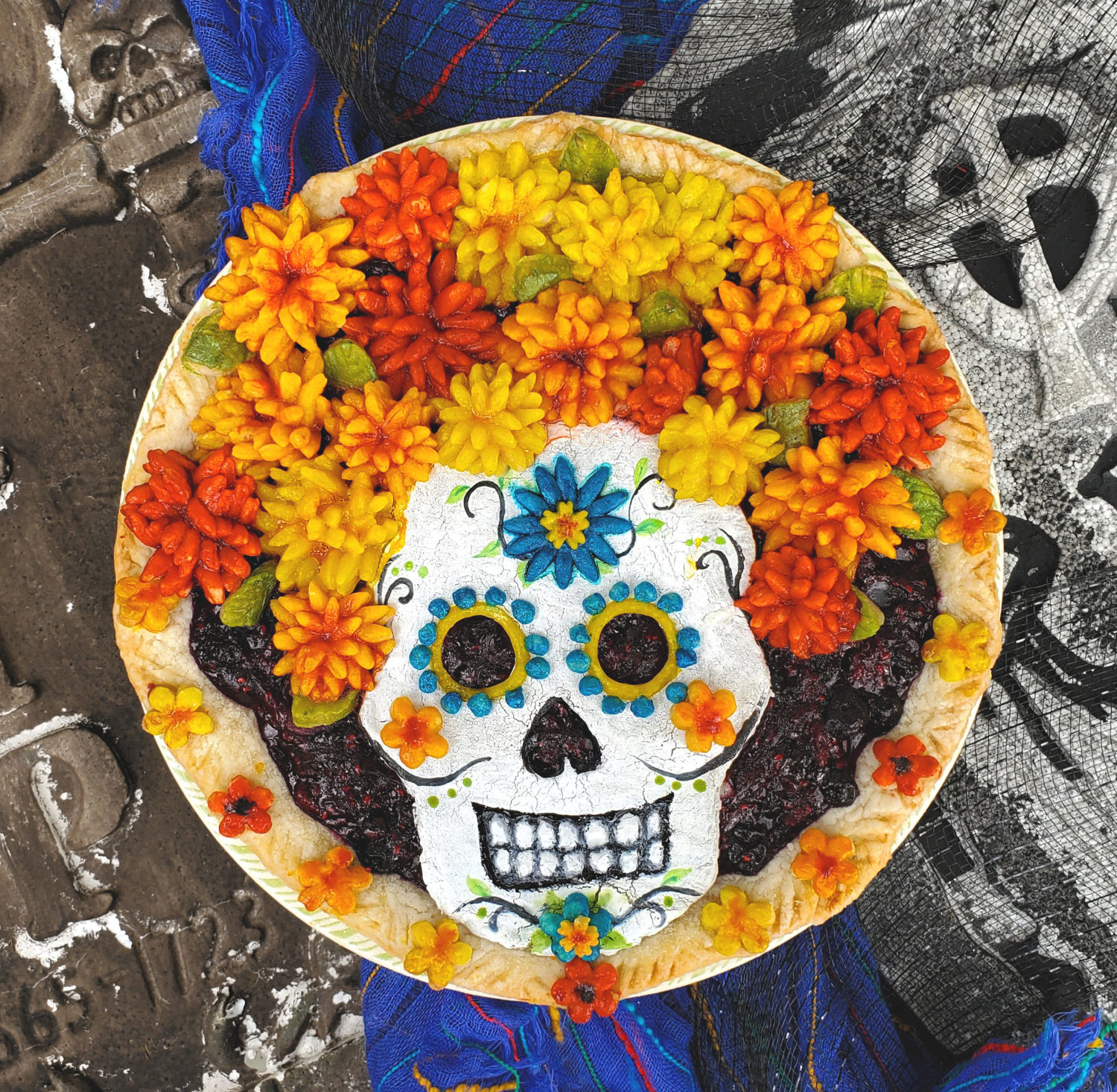 Dia de Muertos with pie crust marigolds for the perfect headdress for your Catrina Calavera on a triple berry pie, honoring the dead!