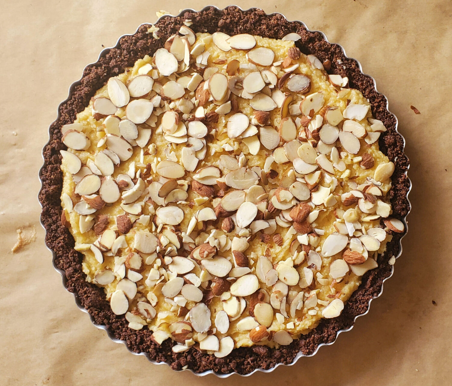 A moist, tender and creamy French almond filling, rippled with a layer of berry jam, topped with sliced almonds and baked in a chocolate almond crust.