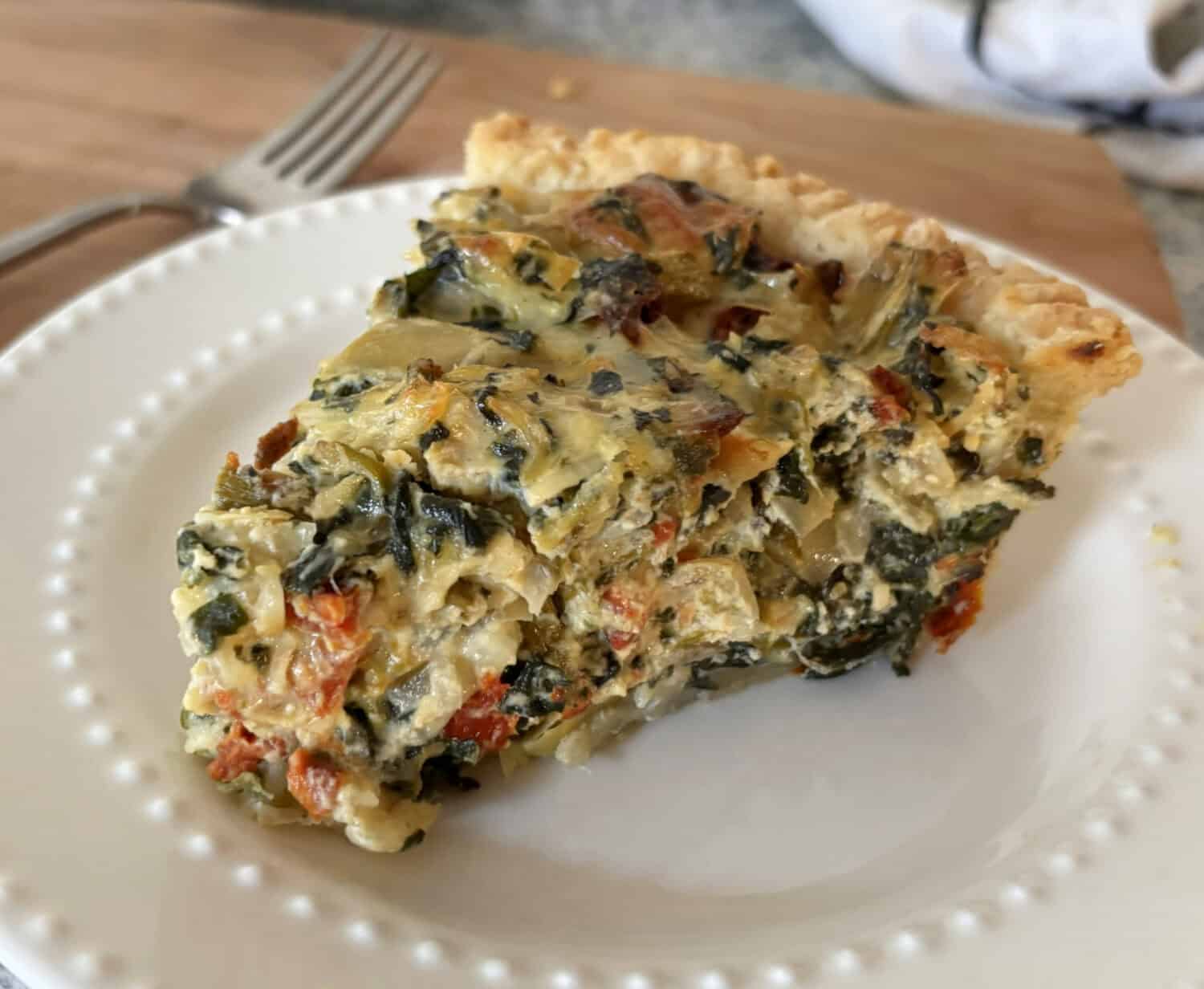 Veggie Frittata: Loads of sweet onions, asparagus, & spinach baked with parmesan and swiss cheeses in a savory egg-sour cream filling.